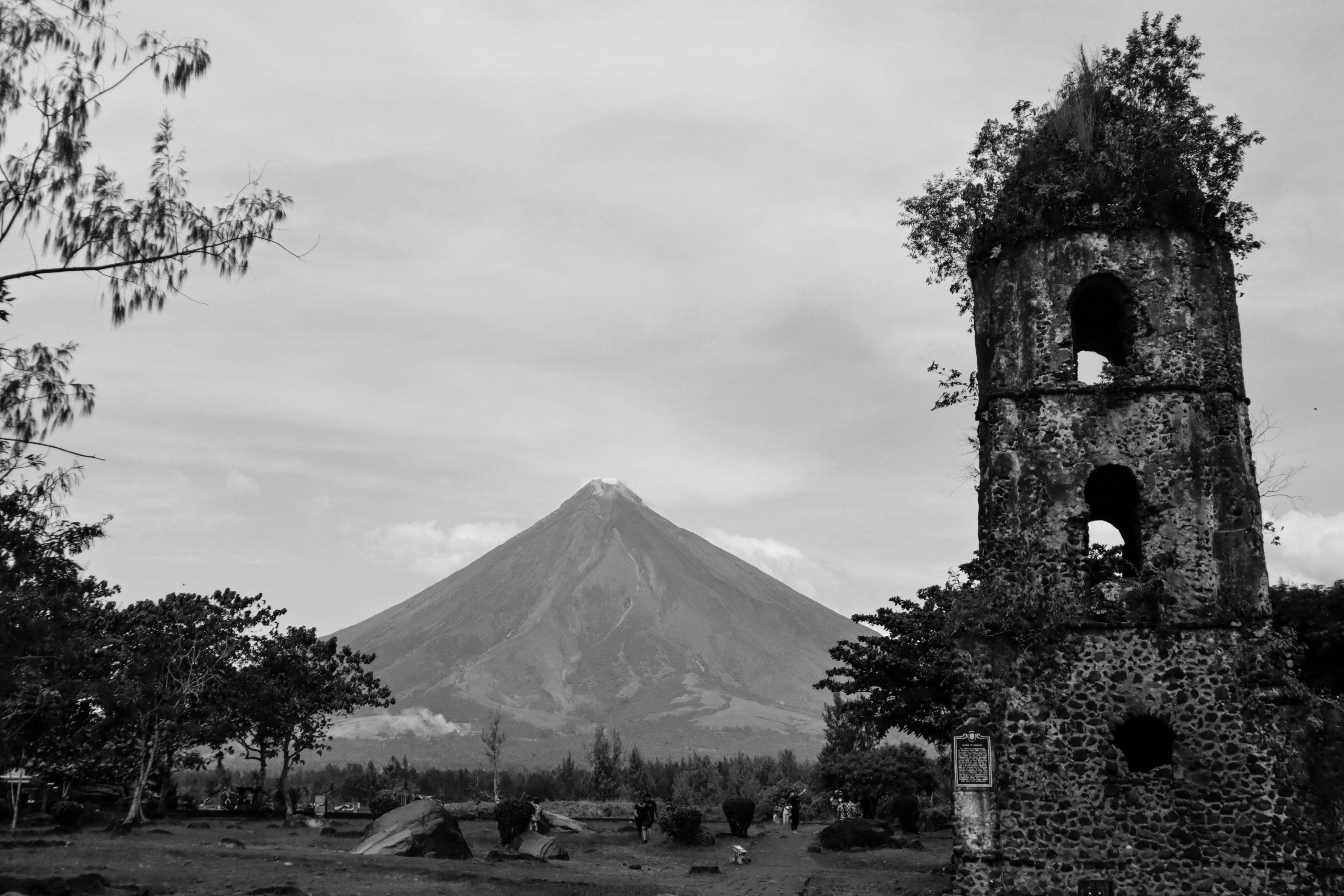 old_tower_with_vegetation_and_a_volcano_in_the_background_2.jpg