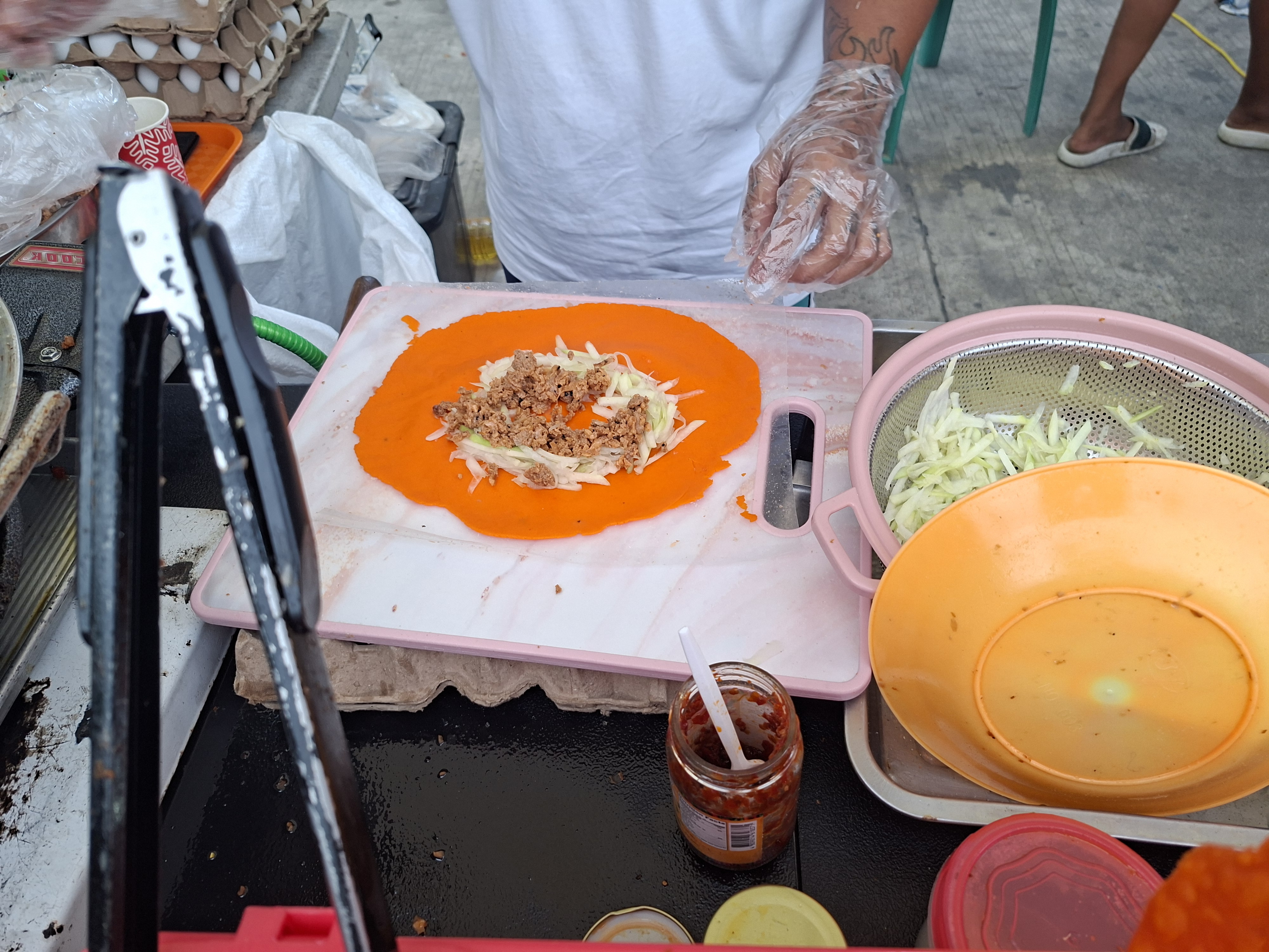 First, they flatten the crust and assemble the filling.